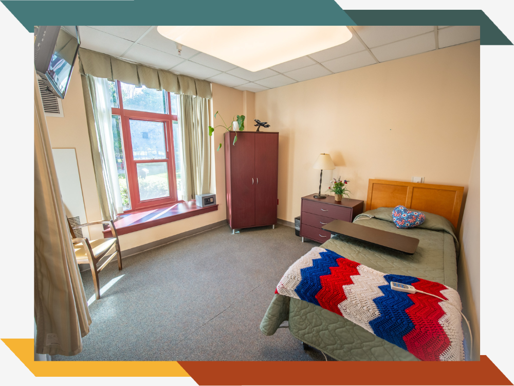 A resident's bedroom with a large window.