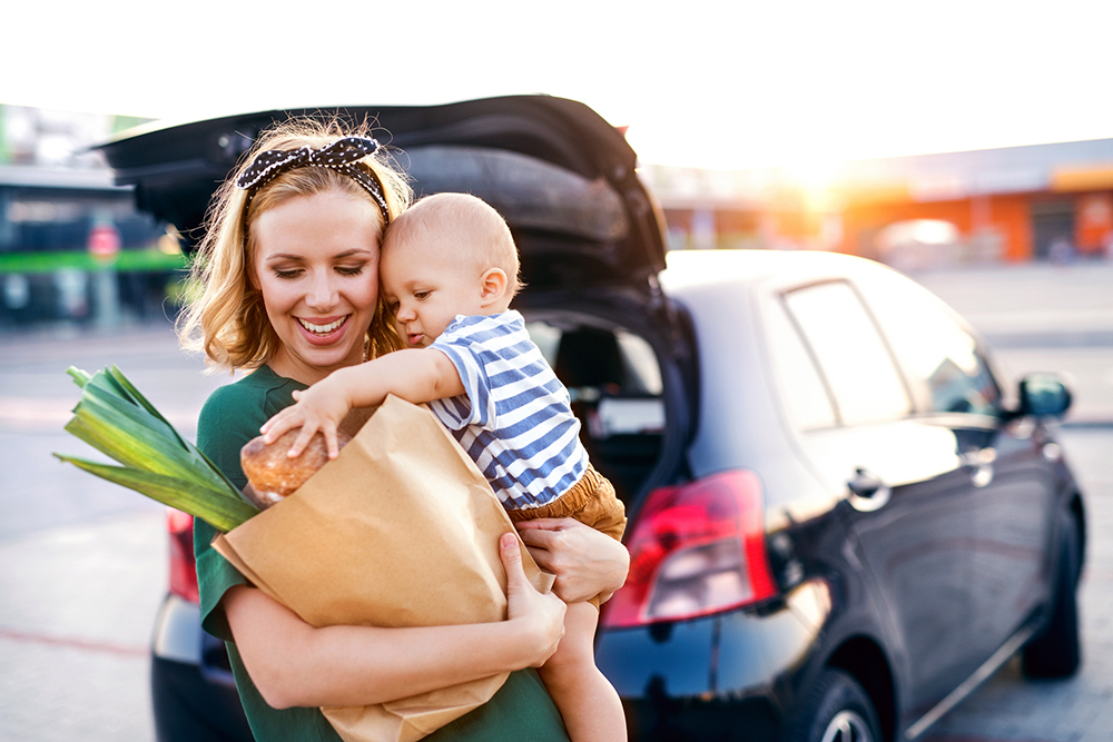 Mother hold groceries and baby