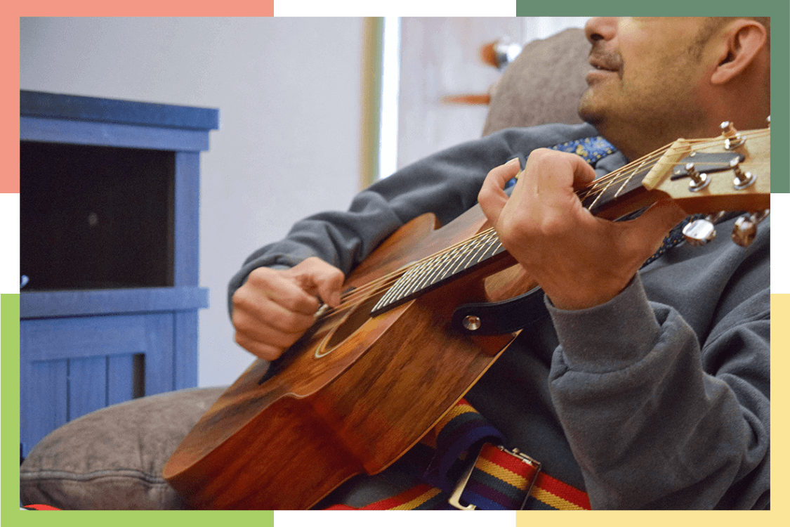 A male Regional Center resident strums a guitar