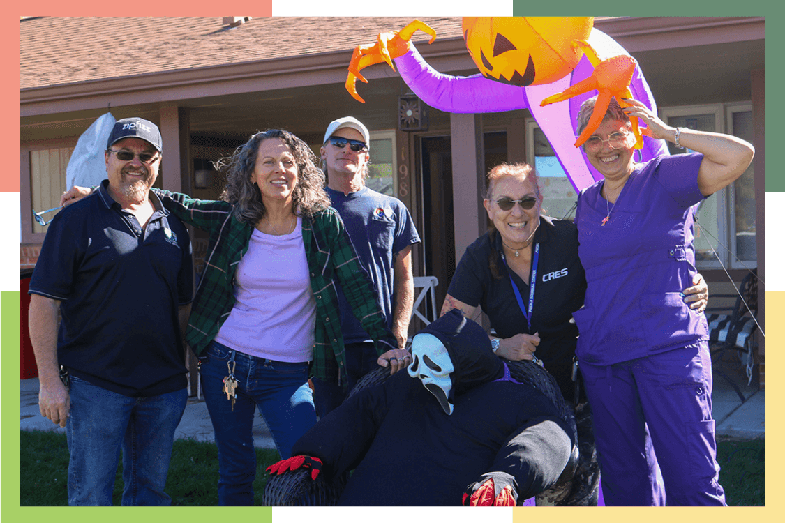 A group of Regional Center staff members smile in front of their assigned home