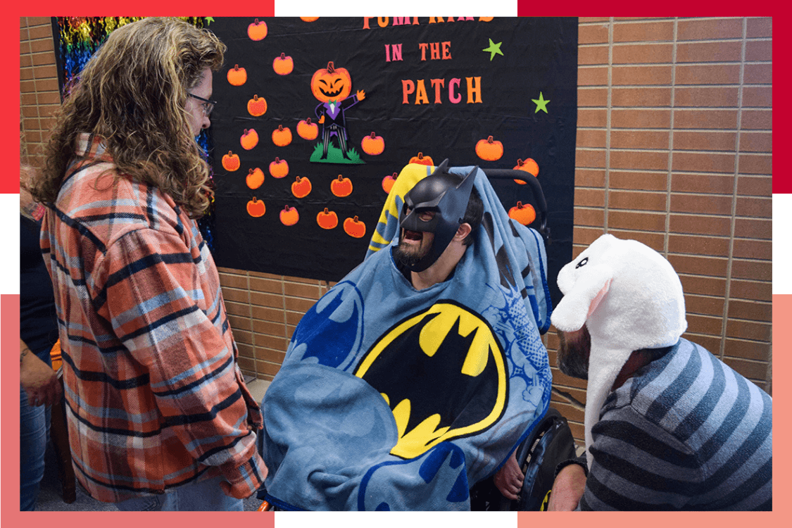 A male Wheat Ridge Regional Center resident wears a Batman Halloween mask and blanket