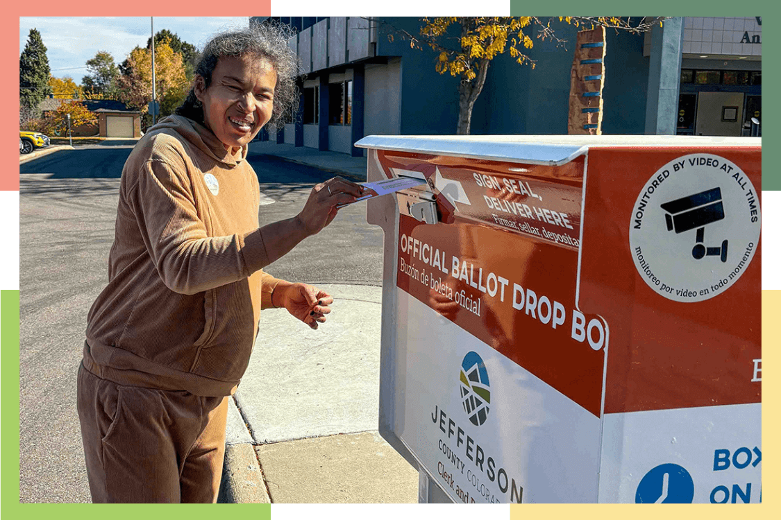 A female Regional Center resident drops her ballot into a ballot box