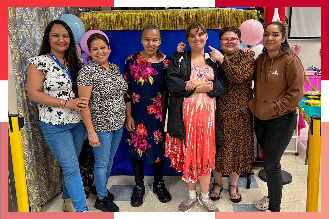 A group of female Wheat Ridge Regional Center residents and staff smile during a party