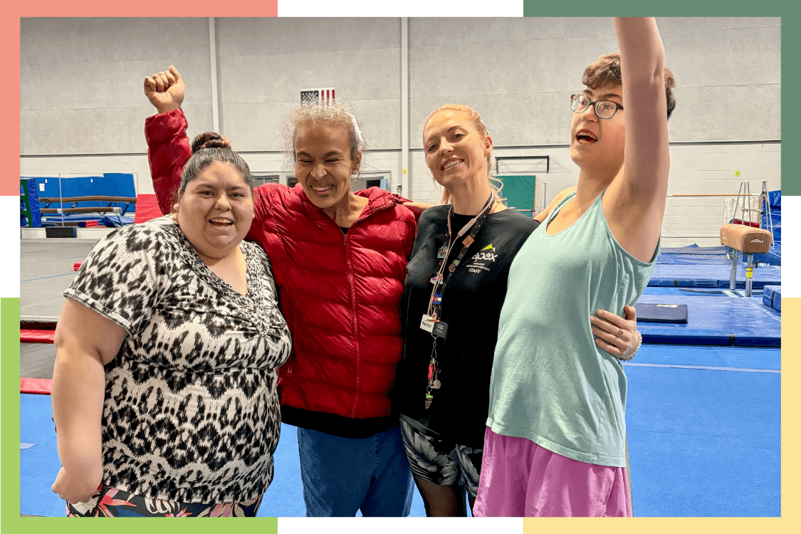 Three residents of Wheat Ridge Regional Center celebrate with a staff member after a gymnastics lesson