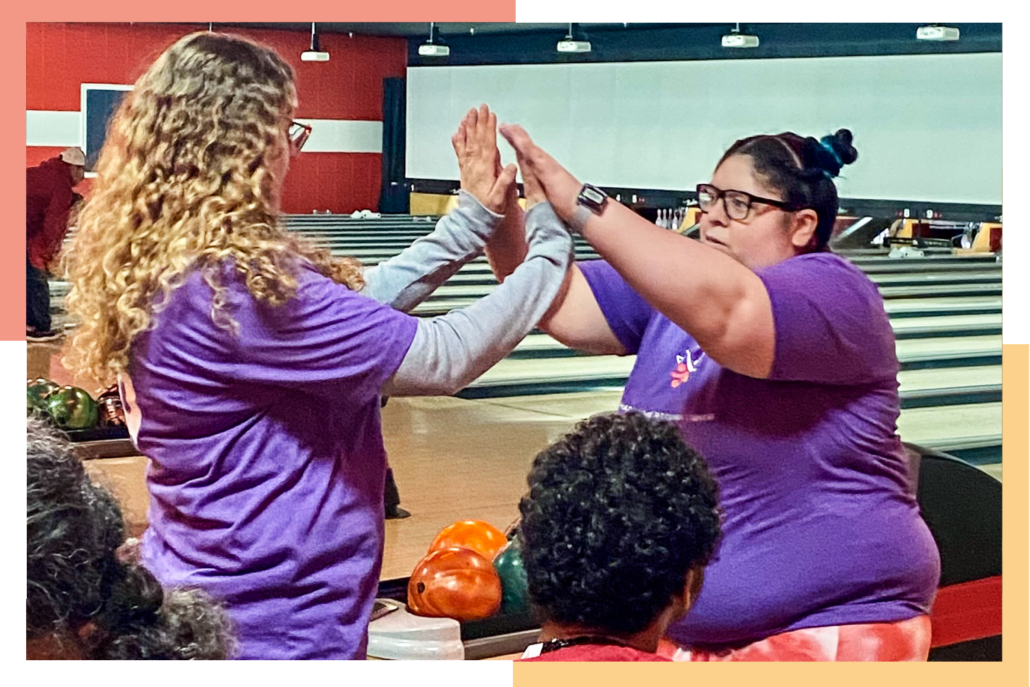 Regional Center resident and staff member high-five during a Special Olympics Colorado bowling tournament.