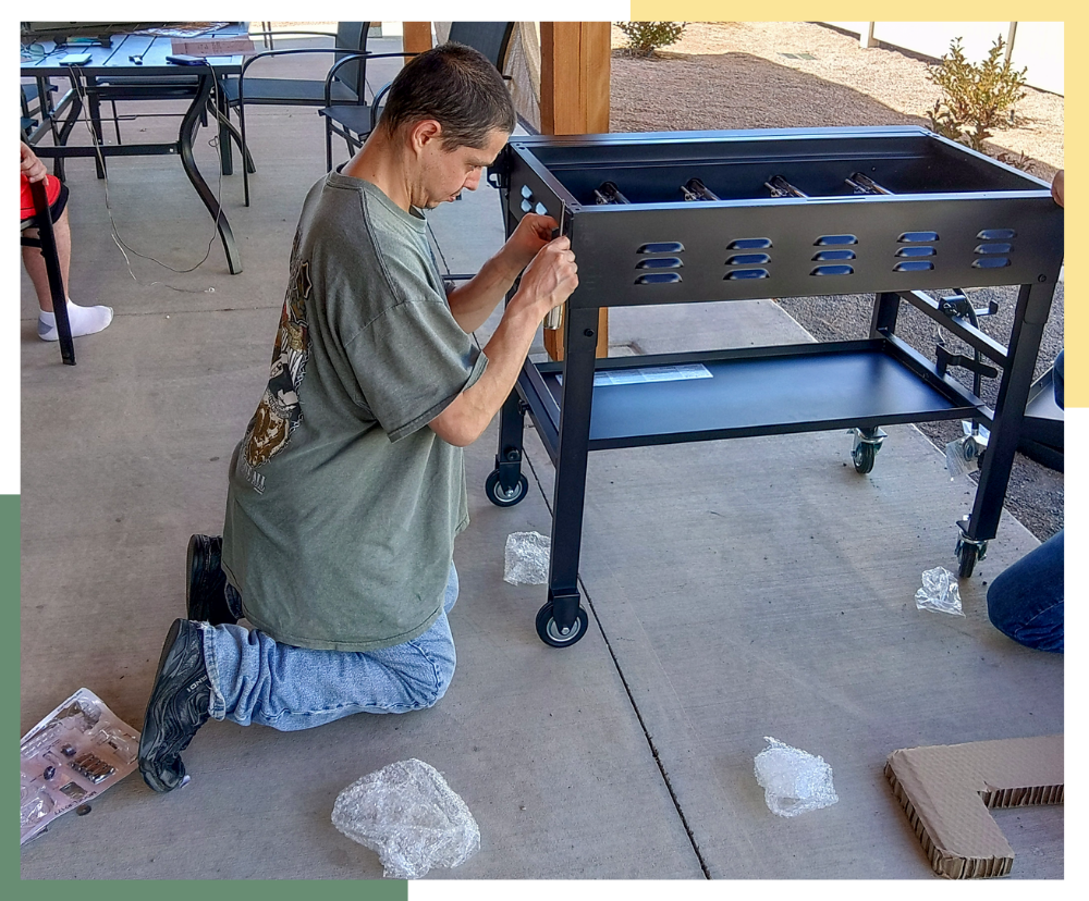 A male Regional Center resident builds an outdoor, metal grill