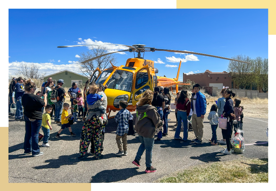 Adults and children gather around a helicopter