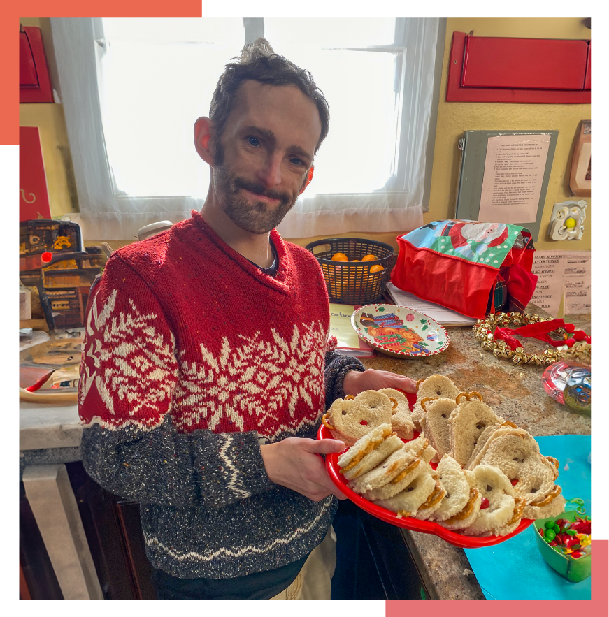 A male Wheat Ridge Regional Center resident holds a tray of sandwiches