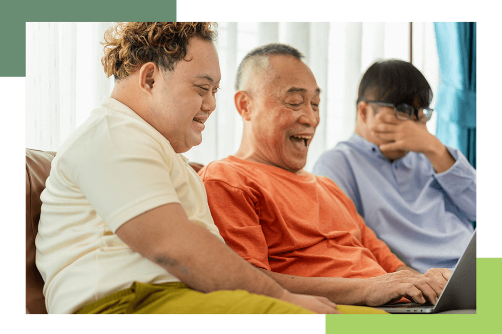 A man with IDD laughs with his family during a video call.