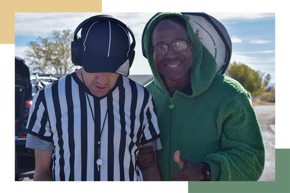 Regional Center resident dressed in a referee Halloween costume and a staff member dressed in an Oscar the Grouch, green, fuzzy Halloween costume