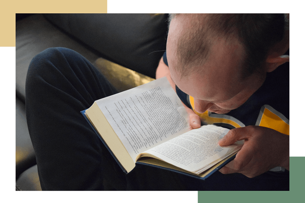 A male resident of Pueblo Regional Center reads a chapter book by himself.