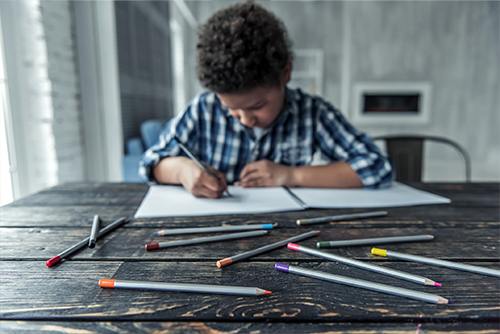 Child drawing with colored pencils