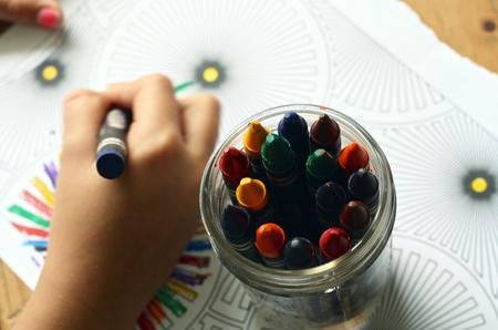 Cup of crayons on a childs drawing