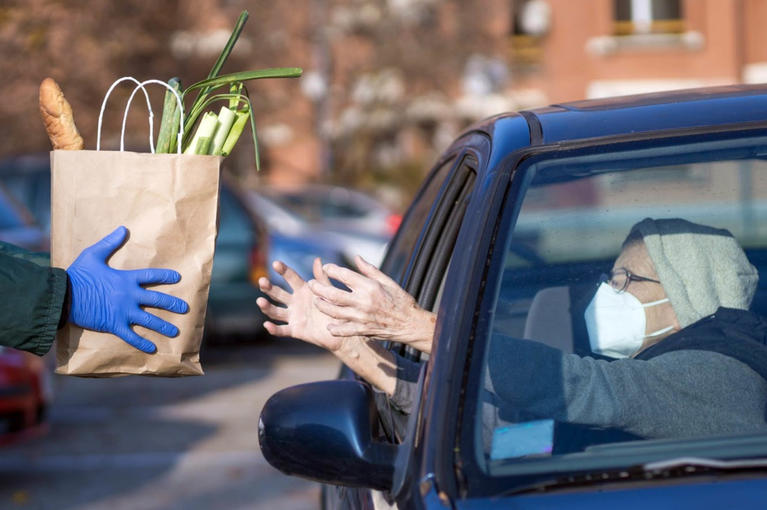 Woman in car receiving bag of food