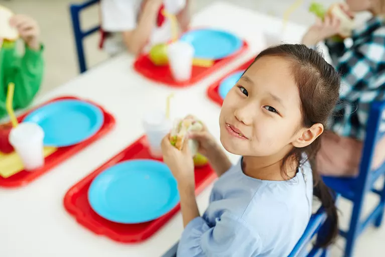 Young girl eating lunch in a cafeteria